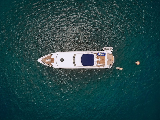 Colpo del drone del bellissimo yacht bianco nel caldo mare blu; concetto di milionario.