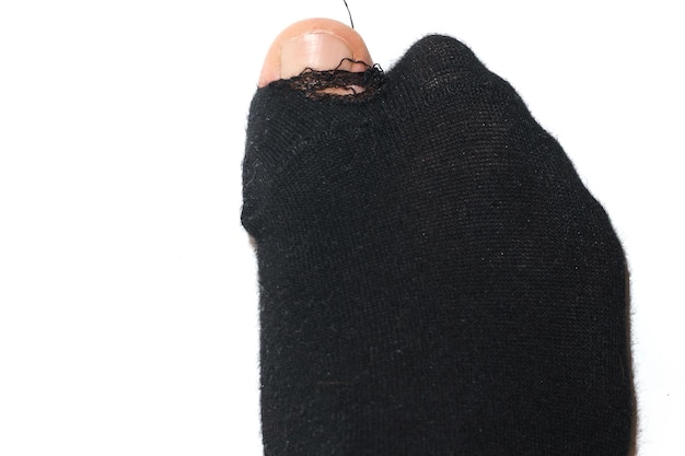 Colpo del primo piano del calzino bucato nero con la punta sporgente