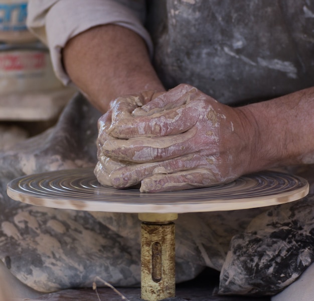 Colpo del primo piano delle mani dei vasai dell'artigiano che scolpiscono il vaso