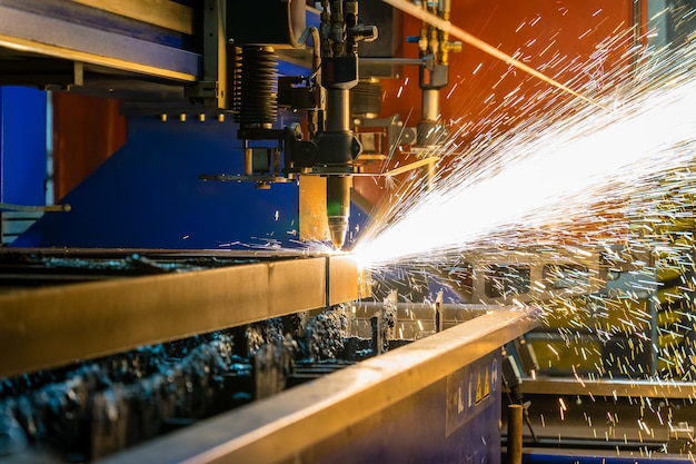 Colpo del primo piano di scintille che volano da una taglierina d'acciaio industriale