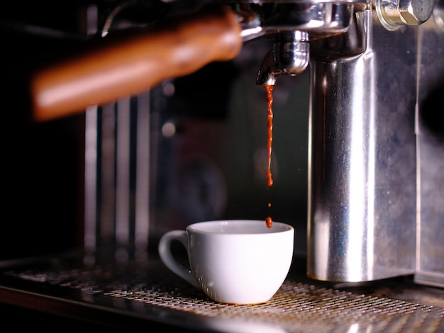 Colpo del primo piano di un espresso che corre in una tazza