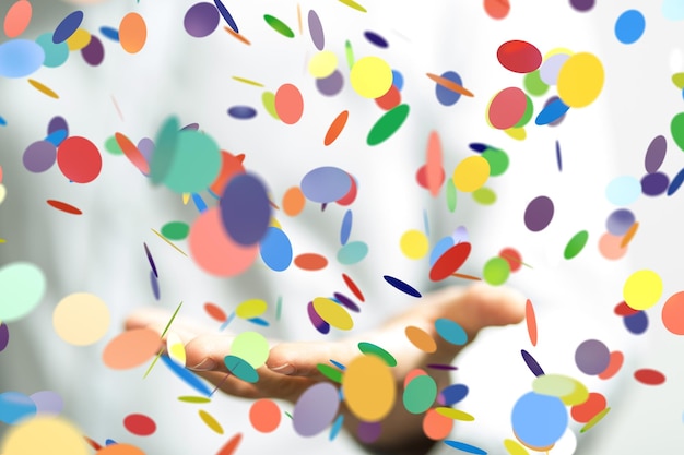 Colpo del primo piano di una persona che presenta la proiezione virtuale di coriandoli colorati