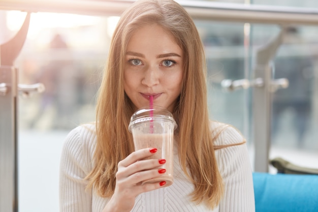 Colpo dell'interno del cocktail del latte alimentare della bella giovane donna