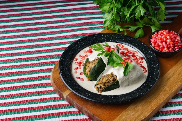 Colpo di alto angolo di Chiles en nogada in un piatto su una tavola di legno sul tavolo