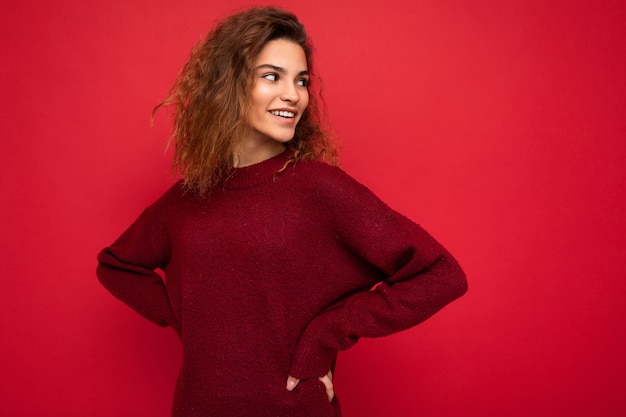 Colpo di attraente giovane donna sorridente felice che indossa abiti casual in piedi isolato su colorito