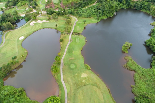 Colpo di drone con vista aerea del bellissimo fairway del campo da golf verde e dell'immagine dall'alto verso il basso verde per lo sfondo dello sport e lo sfondo della natura di viaggio Vista incredibile