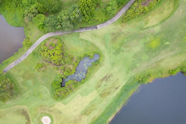 Colpo di drone con vista aerea del bellissimo fairway del campo da golf verde e dell'immagine dall'alto verso il basso verde per lo sfondo dello sport e lo sfondo della natura di viaggio Vista incredibile