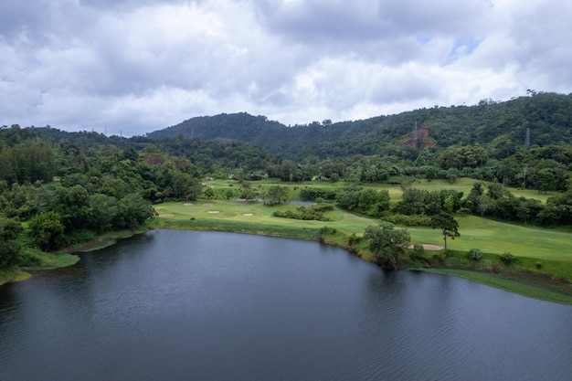 Colpo di drone con vista aerea del bellissimo fairway del campo da golf verde e dell'immagine dall'alto verso il basso verde per lo sfondo dello sport e lo sfondo della natura di viaggio Vista incredibile