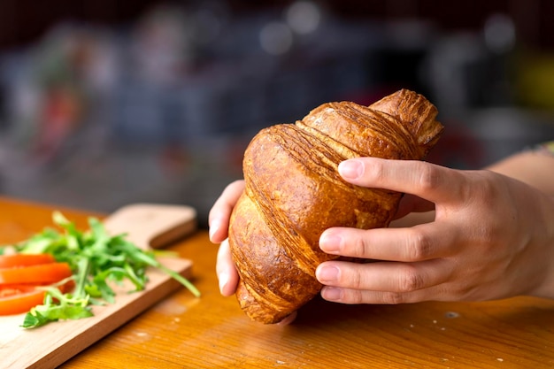 Colpo di messa a fuoco selettiva delle mani femminili che tengono croissant freschi dalla panetteria serba