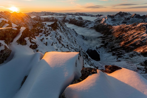 Colpo di montagne innevate nella luce del sole del mattino d'inverno