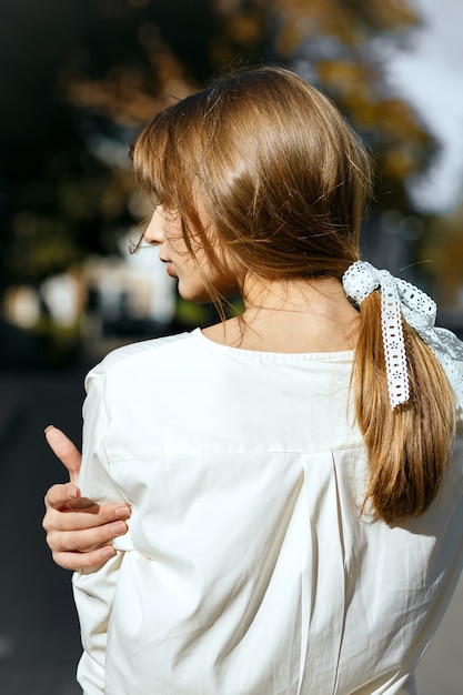 Colpo di strada di una bellissima modella bruna con un nastro nei capelli