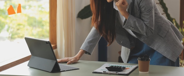 Colpo di una giovane impresa asiatica Donna che lavora al computer portatile nella sua postazione di lavoro