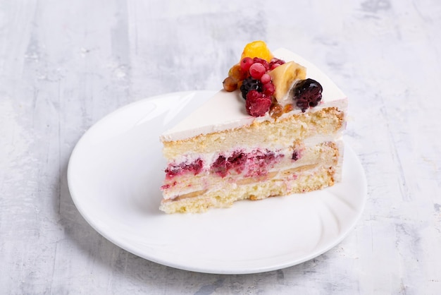Colpo di vista dall'alto di torta di frutta bianca affettata su un piatto bianco