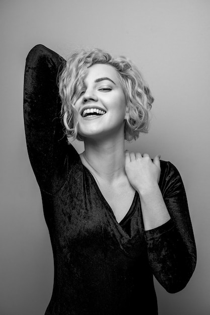 Colpo in testa della giovane signora attraente splendida con sorridere dei capelli ricci. Immagine in bianco e nero. Marilyn Monroe.