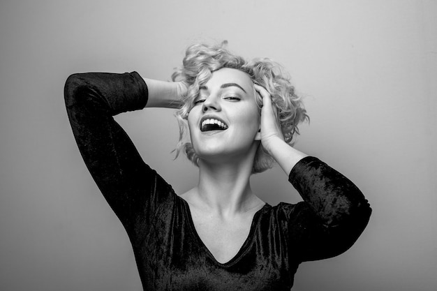 Colpo in testa della giovane signora attraente splendida con sorridere dei capelli ricci. Immagine in bianco e nero. Marilyn Monroe.