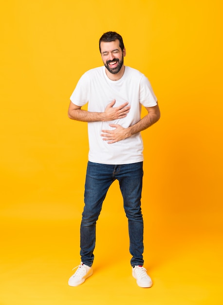 Colpo integrale dell'uomo con la barba sopra giallo che sorride molto