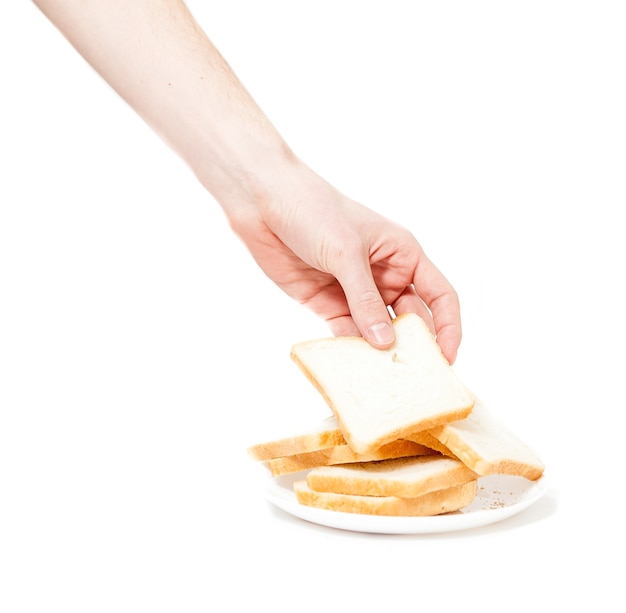 Colpo isolato della mano maschio che attacca pezzo di pane per i toast