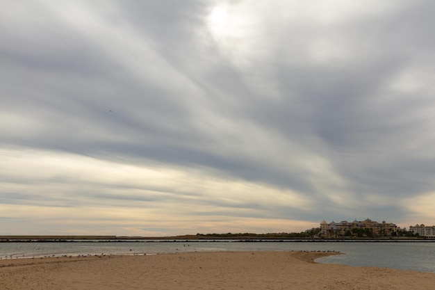 colpo lungo di un paesaggio di una spiaggia spagnola con la bassa marea in una giornata nuvolosa