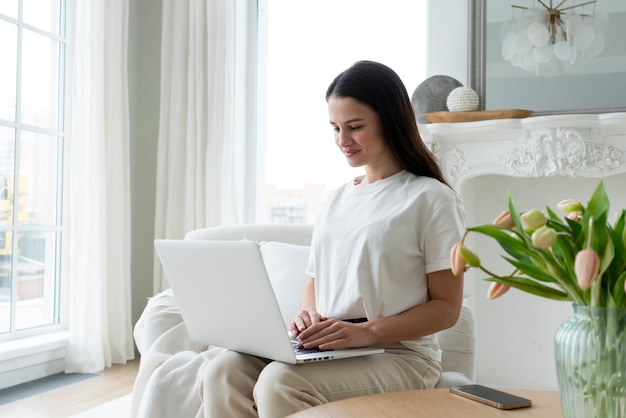 Colpo medio donna che lavora al computer portatile