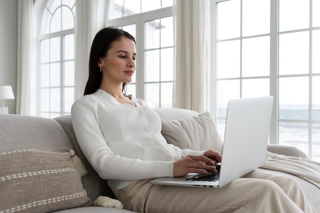 Colpo medio donna che lavora al computer portatile