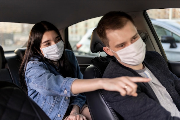 Colpo medio donna e autista con maschera