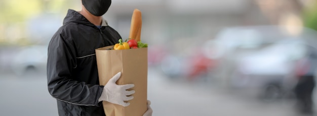 Colpo potato dell'uomo di servizio di distribuzione di alimenti che tiene la borsa dell'alimento fresco