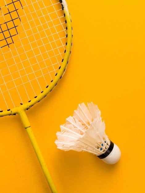 Colpo verticale di badminton su una superficie gialla sotto le luci