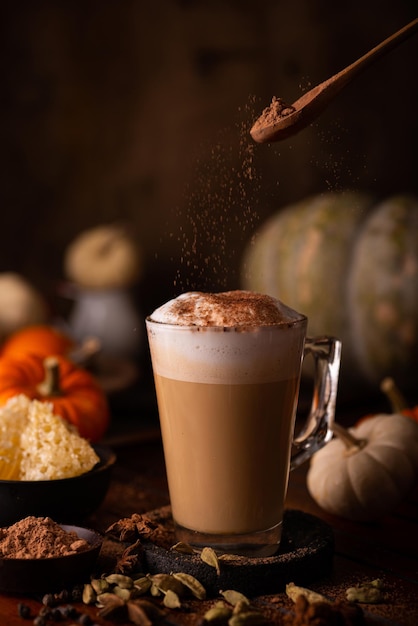 Colpo verticale di caffè latte con cannella in cima