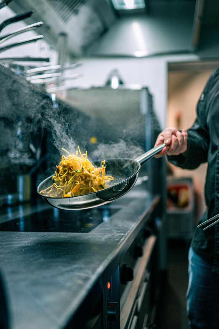 Foto colpo verticale di cuoco professionista durante la preparazione del cibo