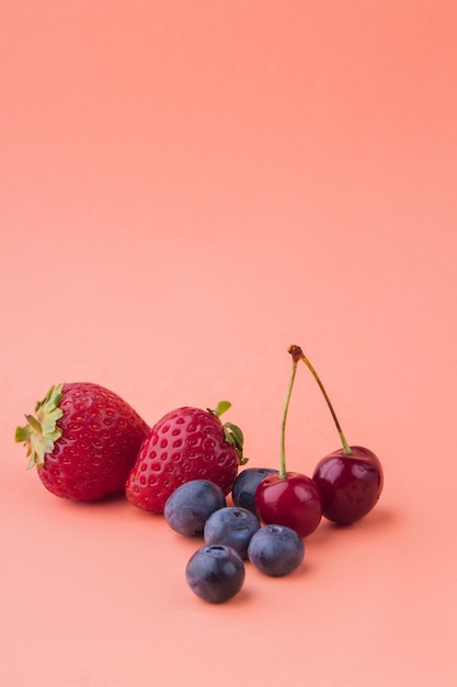 Colpo verticale di frutti freschi maturi isolati su sfondo arancione