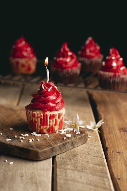 Colpo verticale di una candela cupcake con crema rossa