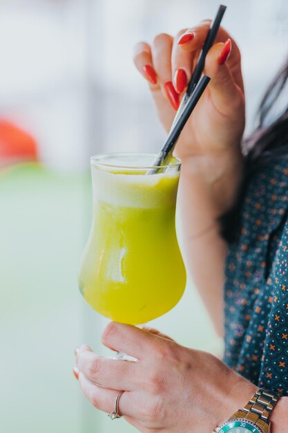 Colpo verticale di una donna che beve un cocktail di mele