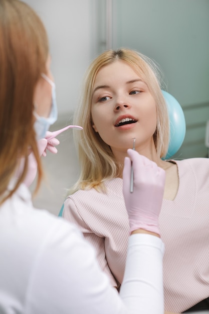 Colpo verticale di una giovane donna che ottiene controllo dentale presso la clinica