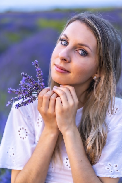 Colpo verticale di una giovane donna in posa in un campo di lavanda