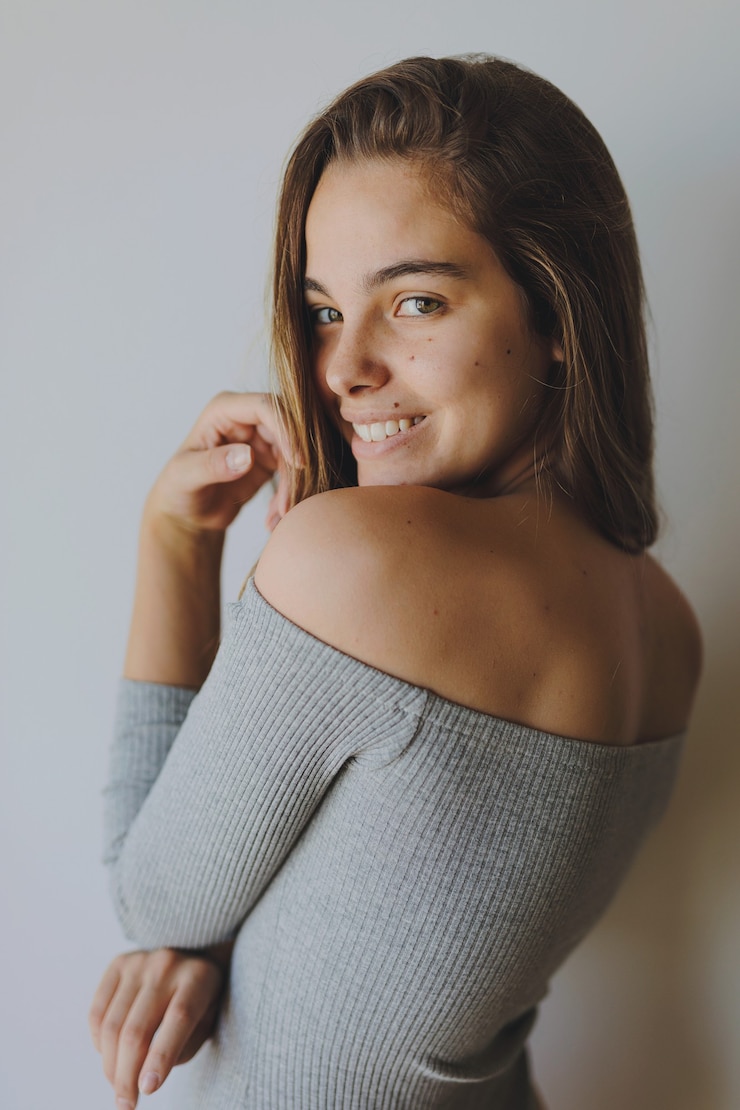colpo verticale ritratto di una giovane donna bionda in corpo grigio