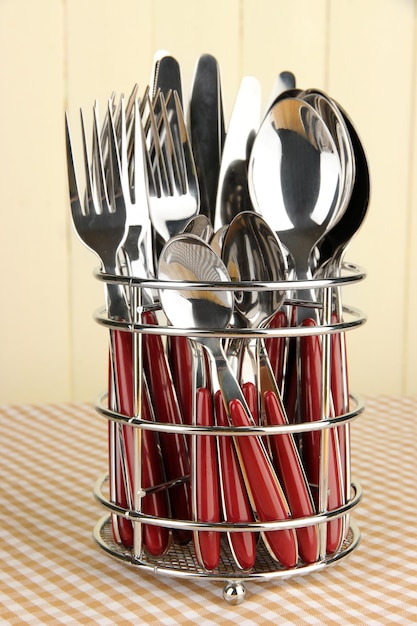 Coltelli forchette e cucchiai in metallo stand sulla tovaglia su sfondo beige
