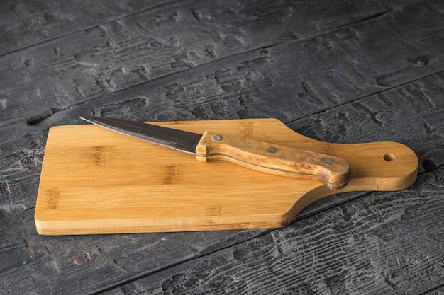 coltello affilato con manico in legno sul tagliere.