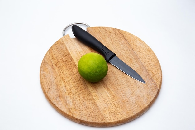 Coltello da cucina nero di lusso e limone sul tagliere isolato su bianco