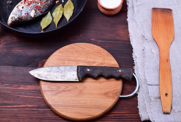 Coltello da cucina su una tavola di legno di taglio circolare