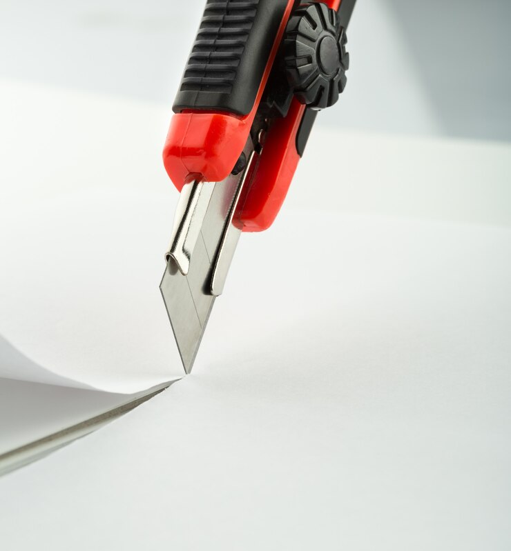 Foto coltello da ufficio rosso isolato
