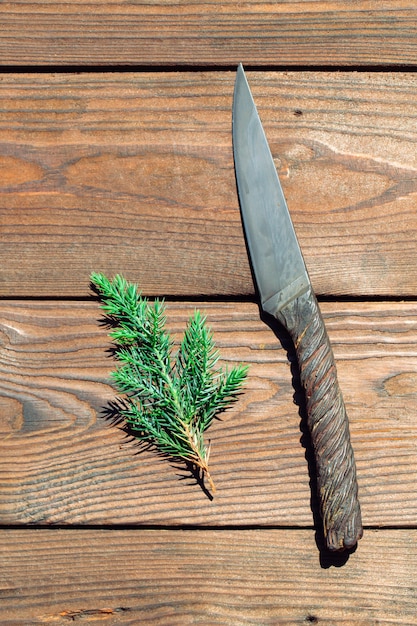 Coltello di un pezzo di metallo fatto della corda della gru del metallo sulla tavola di legno.