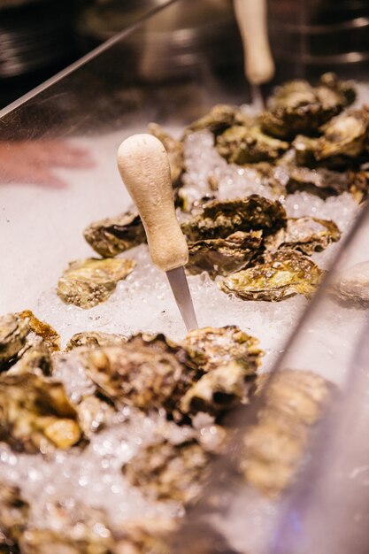 Coltello per shucking un&#39;ostrica fresca che spilla nel ghiaccio