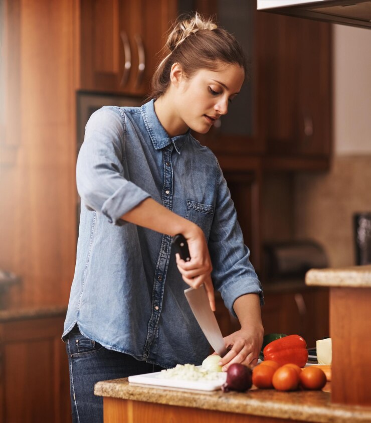 Foto coltello verdure e donna che taglia in cucina per ingredienti biologici pasto sano o insalata in casa lenti flare nutrizione e vegetariano per la dieta preparare la cena o cucinare con prodotti freschi