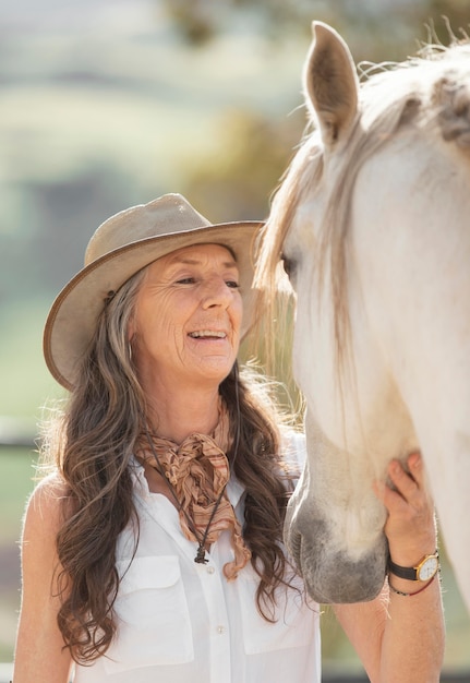 Coltivatore femminile di smiley con il suo cavallo al ranch