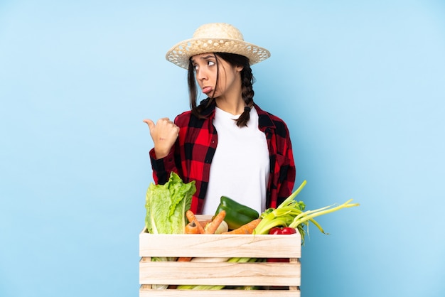 Coltivatore femminile triste con scatola di verdure