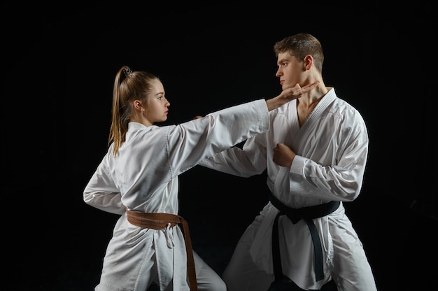 Combattente di karate femminile in allenamento con kimono master, bianco. Karateka in allenamento, arti marziali, combattimento