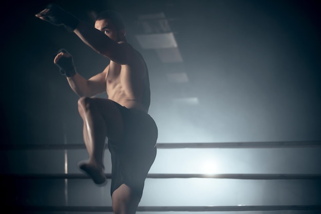 Combattente MMA muscolare che pratica il concetto di kick fight club Foto di alta qualità