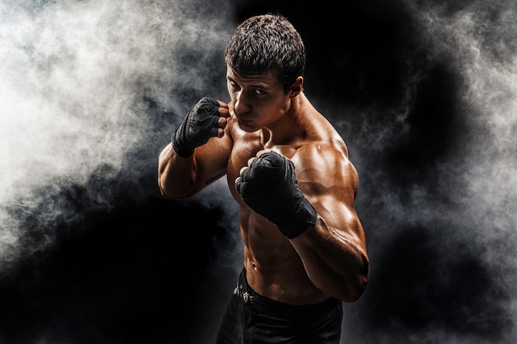 Foto combattente muscolare in topless in guantoni da boxe