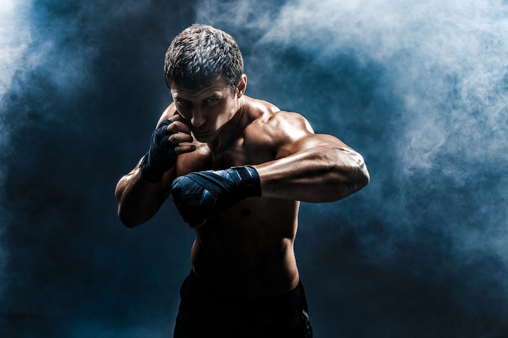 Foto combattente muscolare in topless in guantoni da boxe