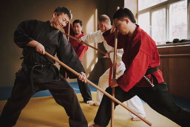 Combattenti di arti marziali di karate che combattono con i bastoni